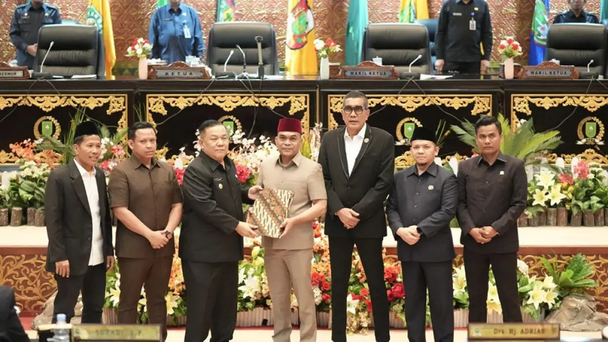 Ketua DPRD Riau Kaderismanto menyerahkan berita acara Rapat Paripurna kepada Pelaksana Tugas (Plt) Gubernur Riau SF Hariyanto disaksikan pimpinan DPRD Riau lainnya, Selasa (21/4/2026). (DPRD RIAU UNTUK RIAU POS)
