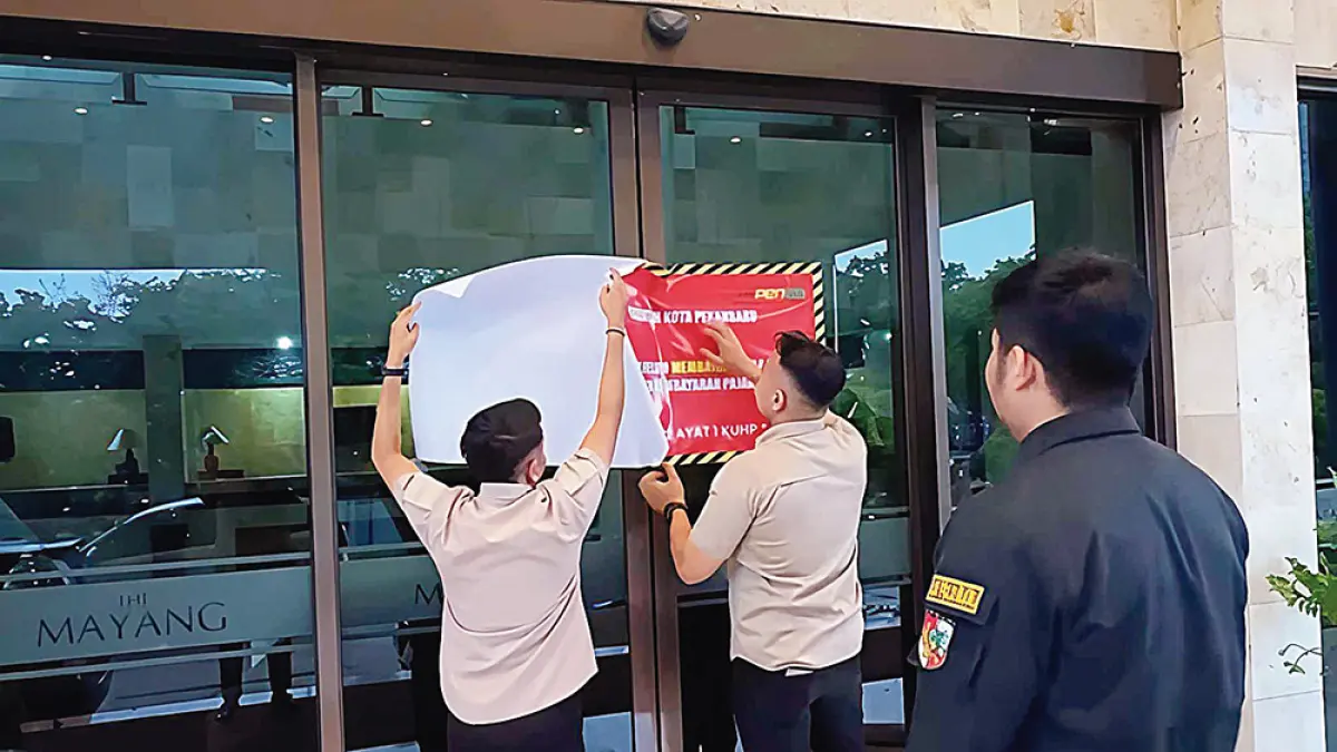 Petugas dari Bapenda Pekanbaru memasang stiker tunggakan pajak di salah satu hotel yang belum melakukan pembayaran pajak daerah, Rabu (22/4/2026). (bapenda pekanbaru untuk riau pos)