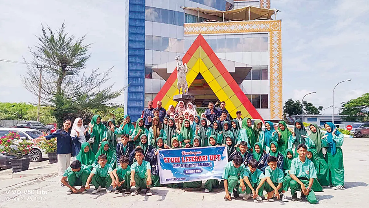 Guru pendamping bersama pelajar SMPN 5 Tambang foto bersama Redpel Riau Pos Syahrul Mukhlis di depan  Graha Pena Riau saat kunjungan ke Riau Pos, Kamis (23/4/2026). (EVAN GUNANZAR)