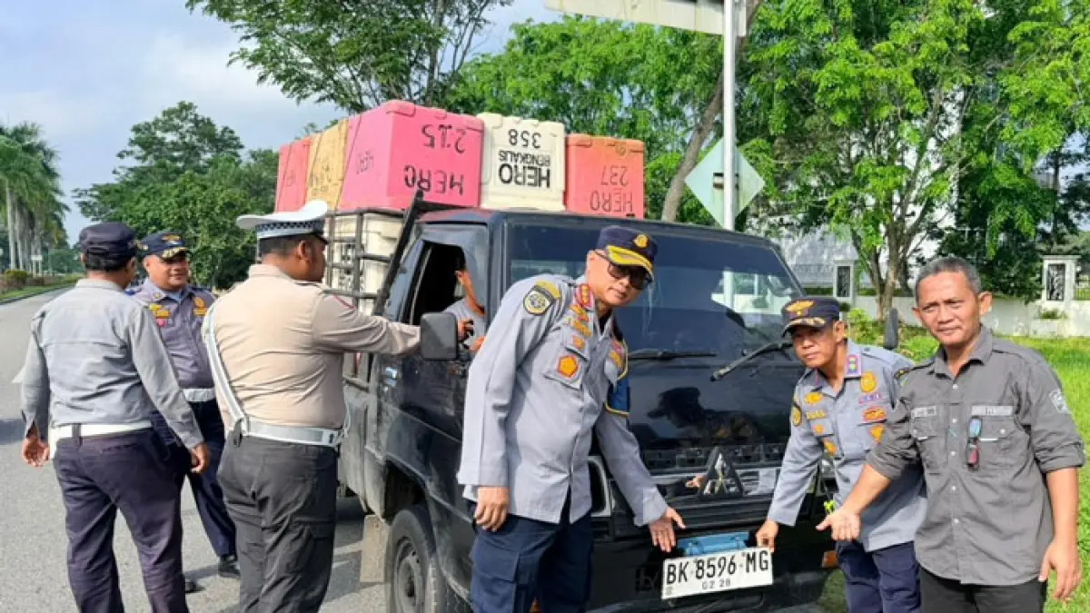 Petugas dari Dishub Siak menunjukkan plat mobil luar daerah saat uji coba penertiban plat nomor kendaraan luar Siak, di depan Pos Dishub ujung Jembatan Tengku Agung Sultanah Latifah (TASL), Kecamatan Mempura, Jumat (24/4/2026). (Istimewa)