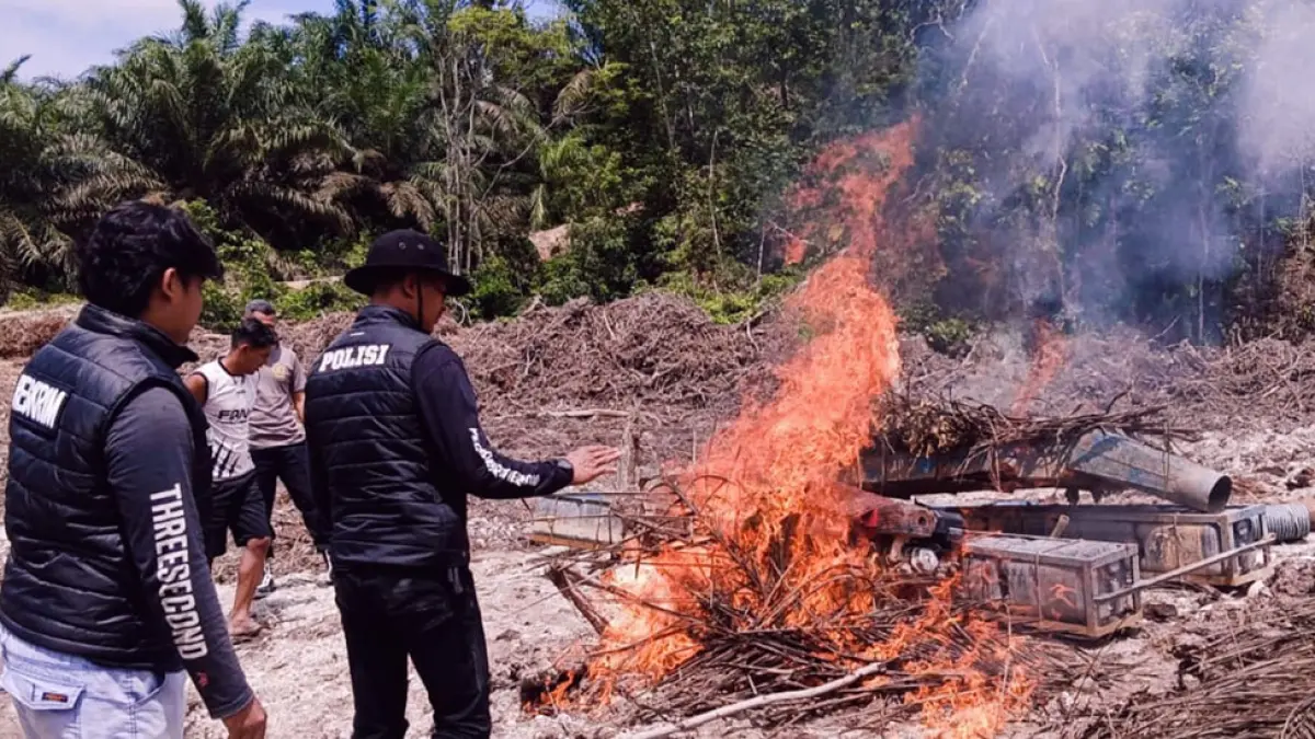 Jajaran Polsek Benai dipimpin Kapolsek Ipda Ali Sodiq membakar rakit robin saat melakukan penertiban PETI di Desa Tebing Tinggi Benai, Ahad (26/4/2026). (Polsek Benai untuk riau pos)
