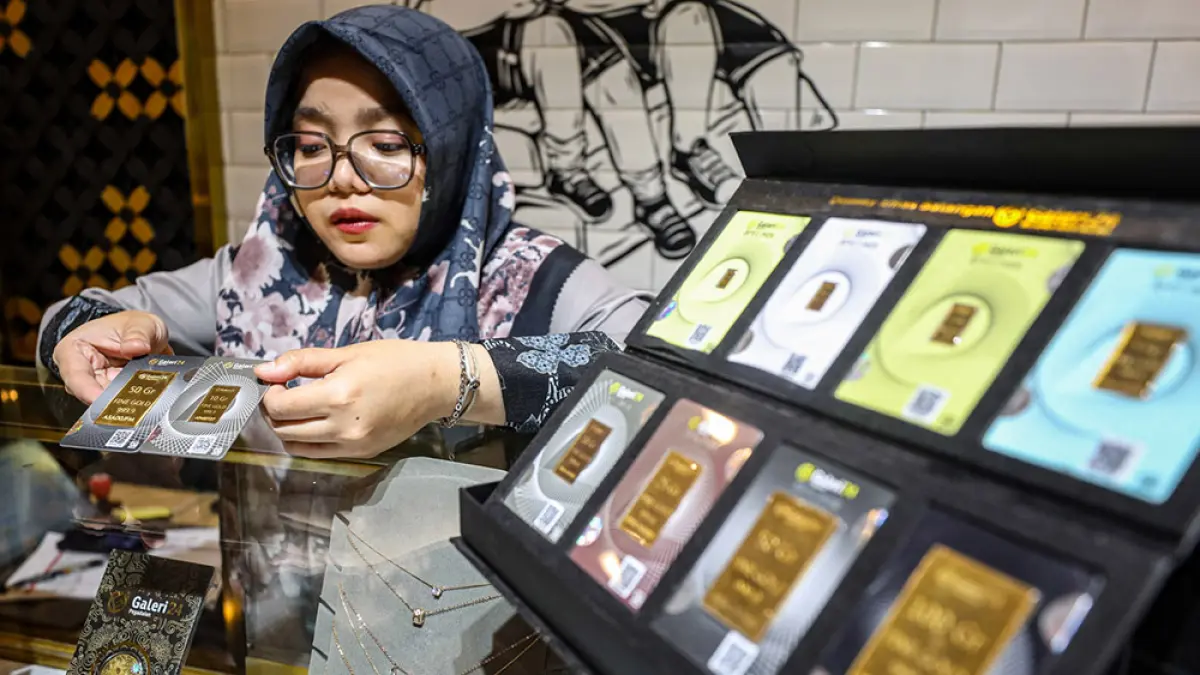 Seorang karyawan saat menunjukkan batangan emas Antam yang dijual di toko perhiasan tersebut, belum lama ini. (JPG)