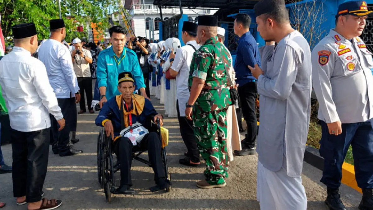 Jemaah calon haji duduk di atas kursi roda sambil didorong petugas menuju kapal cepat di Pelabuhan Lasdap Tembilahan untuk berangkat menuju embarkasi batam, Selasa (28/4/2026). (Istimewa)