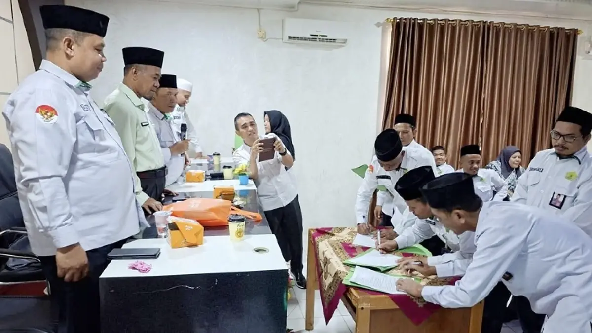 Kakan Kemenag Rohul H Zulkifli Syarif (dua kiri) menyaksikan sejumlah Kepala KUA menandatangani fakta integritas disela-sela rapat koordinasi di aula Kantor Kemenag Rohul, Senin (27/4/2026). (Kemenag Rohul untuk Riaupos.co)