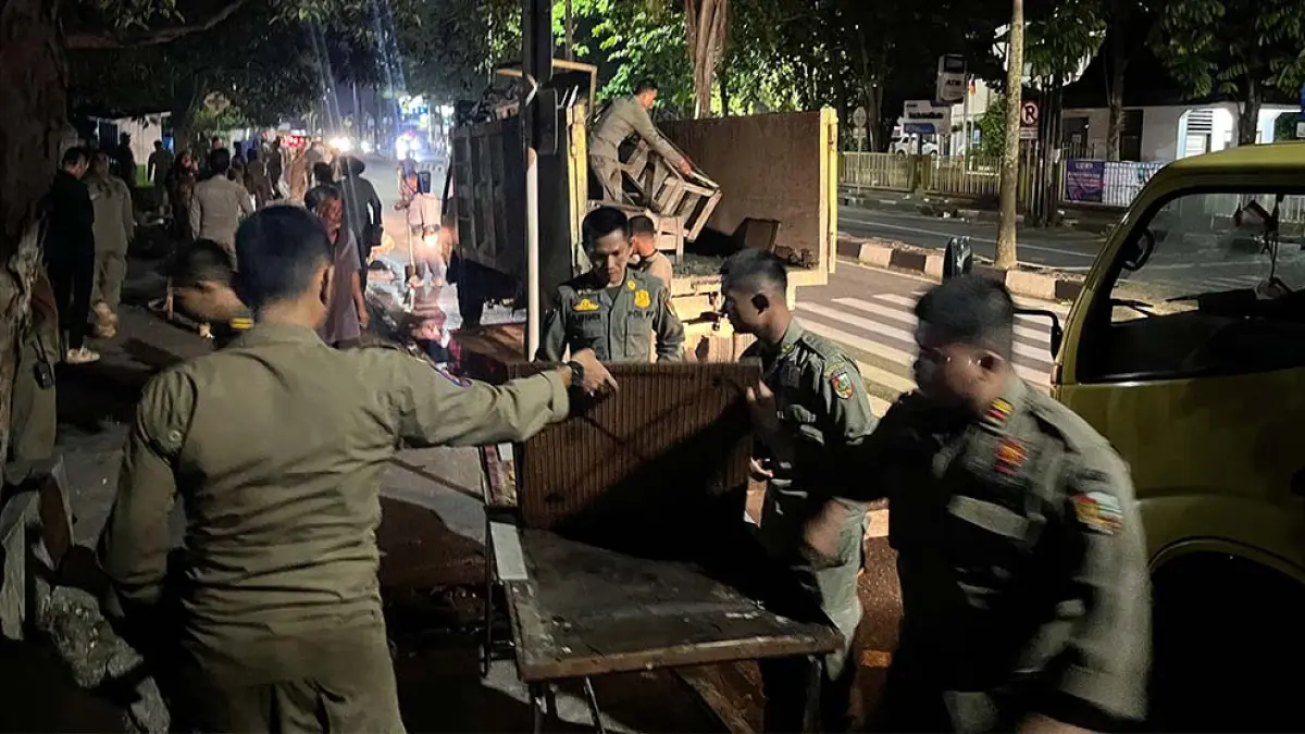 Petugas Satpol PP Pekanbaru bersama tim Kecamatan Sail mengangkut lapak-lapak yang ditinggalkan  PKL di atas trotoar di Jalan Pattimura, Selasa (28/4/2026) dini hari. (HUMAS KECAMATAN SAIL UNTUK RIAU POS)