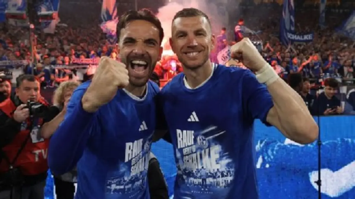 Edin Dzeko (kanan) dan Kenan Karaman dari Schalke merayakan promosi ke Bundesliga di depan para penggemar. (Lars Baron/Getty Images)