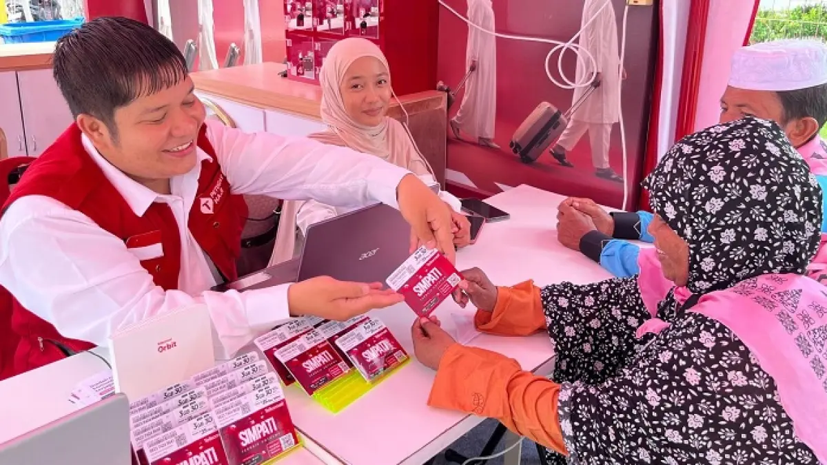 Customer Services Telkomsel menyerahkan paket RoaMax Haji kepada pelanggan yang datang ke Posko Siaga di Batam, Senin (4/5/2026). (TELKOMSEL UNTUK RIAU POS)