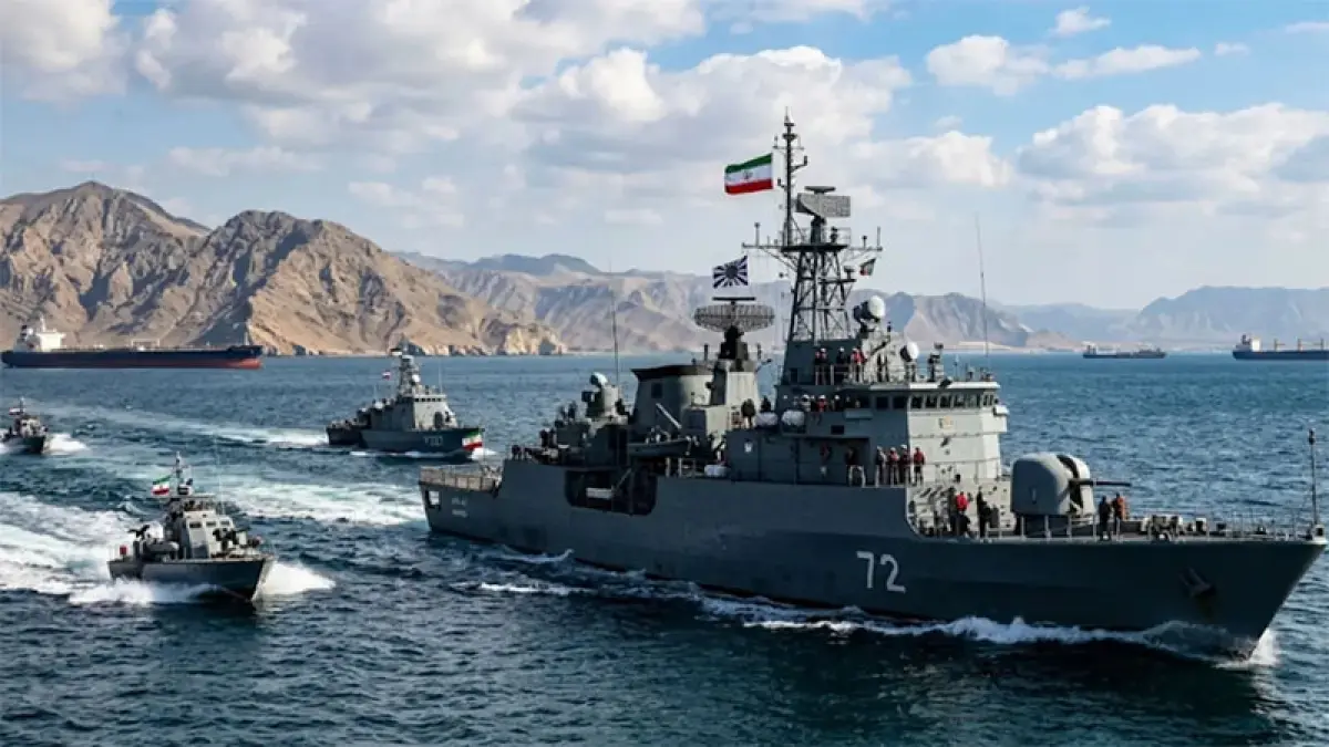Ilustrasi armada angkatan laut Iran berpatroli di Selat Hormuz dengan kapal tanker minyak melintas di kejauhan. (Gemini AI)

