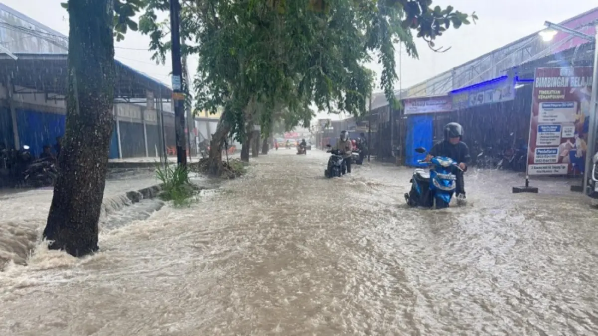 Pengendara motor yang melintas di Jalan Kusuma Kecamatan Bukit Raya mendorong kendaraannya yang mogok karena genangang air banjir mencapai paha orang dewasa, Senin (4/5/2026). (Prapti Dwi Lestari/Riaupos.co)
