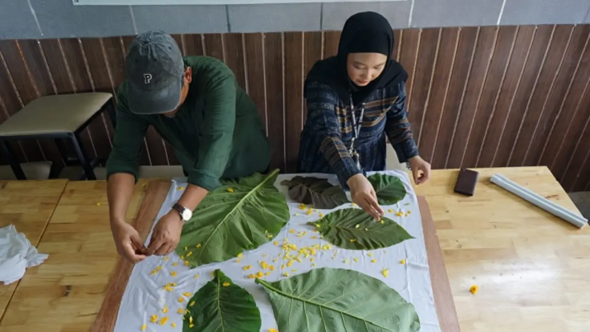 Pengelola Sugeng dan Nurul &nbsp;melakukan proses pembuatan Eco Print yang dilakukan di Bank Sampah Agro Wisata Ibnu Al Mubarok Rumbai , Selasa (5/5/2026). Dalam Sebulan Bank Sampah Agro Wisata Ibnu Al Mubarok mampu memproduksi hingga 100 batik ECO print. (EVAN GUNANZAR/RIAU POS)