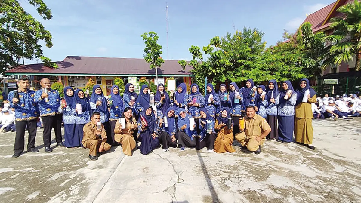 Kepala SMP Negeri 29 Pekanbaru Erlinawati MPd (berdiri sebelas kanan), Wakasis Emilidar Zulkarnaini SPd (sepuluh kanan), dan Wakakur Dewi Susanti ST (delapan kiri) foto bersama majelis guru saat sosialisasi penggunaan tempat minum (tumbler) mengurangi sampah plastik dari air mineral bagi seluruh warga, beberapa waktu lalu. (SMP Negeri 29 Pekanbaru)