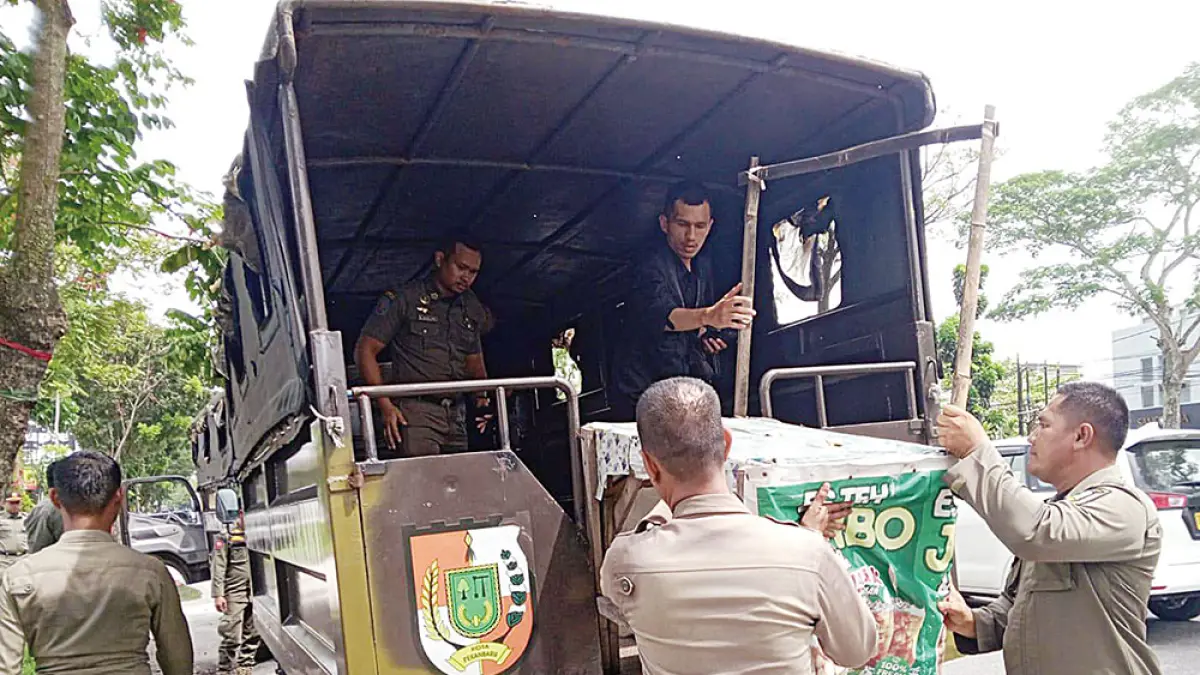Petugas Satpol-PP Pekanbaru menertibkan dan mengangkut lapak PKL di Jalan HR Soebrantas yang dibangun secara permanen di atas trotoar dan saluran drainase, Selasa (5/5/2026). (Prapti Dwi Lestari)
