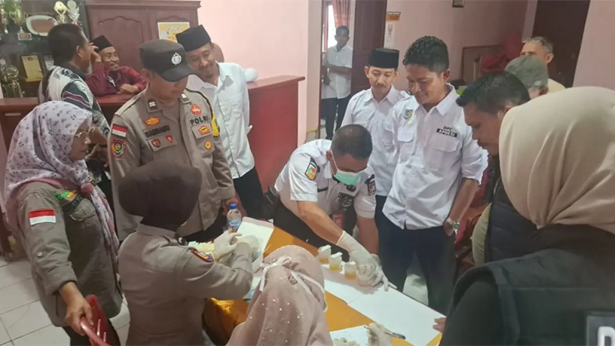 Kapolsek Rupat AKP Faisal SH melihat petugas kesehatan melakukan tes urine perangkat Desa Pangkalan Nyirih. (ISTIMEWA)
