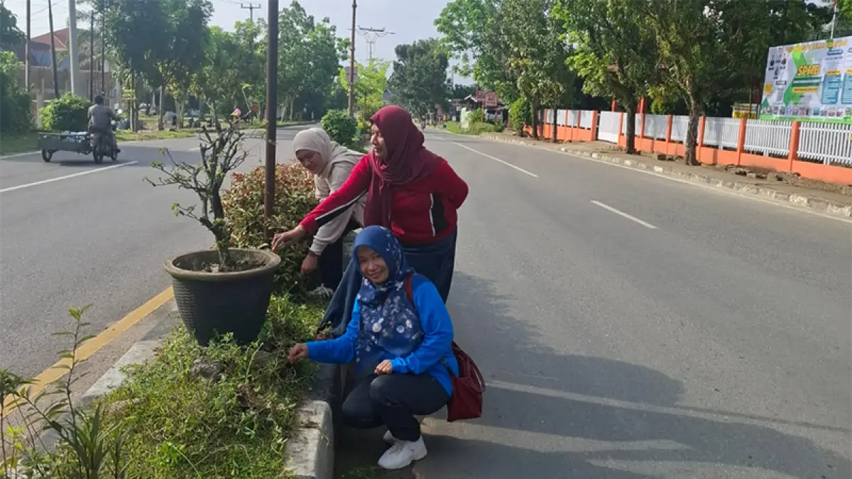 ASN di Kecamatan Kuantan Tengah membersihkan taman di ruas Jalan Proklamasi Teluk Kuantan, Jumat (8/5/2026). (Desriandi Candra)