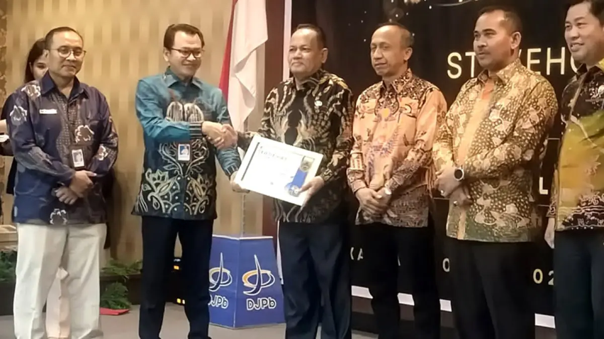 Pj Sekda Rohul H Yusmar MSi didampingi Plt Kepala BPKAD Abdurrochim mewakili Bupati Rohul menerima piagam penghargaan terbaik I atas kinerja realisasi dana transfer ke daerah tahun 2025 dari Kakanwil&nbsp;DJPB Riau Adnan Wimbyarto di aula Lancang Kuning Kantor DJPB Riau, Kamis (7/5/2026). (Dinas Kominfo Rohul untuk Riau Pos) 