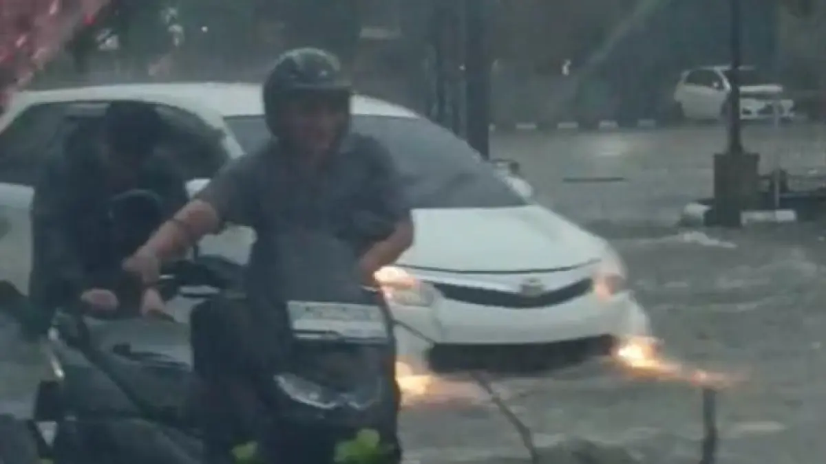 Warga mendorong sepeda motor yang mogok akibat banjir di Jalan HR Soebrantas Pekanbaru, Jumat (8/5/2026). (Foto warga)