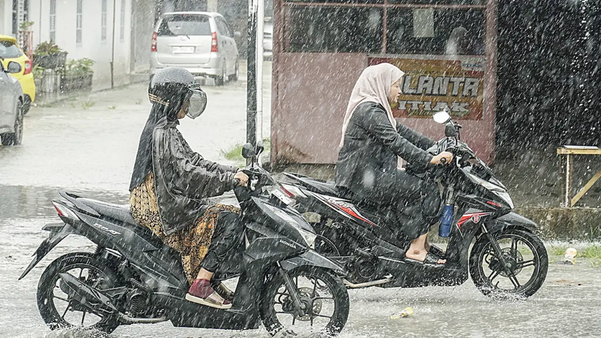Pengendara sepeda motor melintas di Jalan Rambutan saat hujan deras mengguyur Pekanbaru, Jumat (8/5/2026).