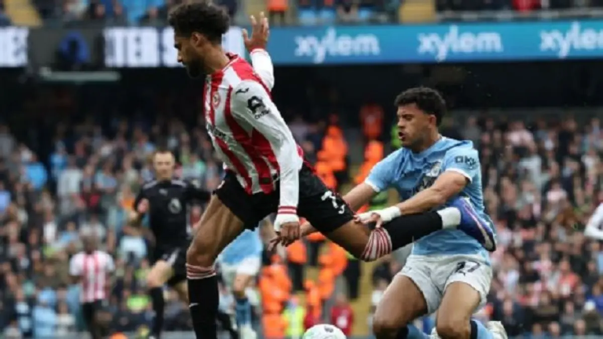 Pemain sayap Brentford, Kevin Schade, terjatuh di area penalti saat ia dan Matheus Nunes dari City bersentuhan, tetapi The Bees tidak diberikan penalti. (Darren Staples/AFP via Getty Images)