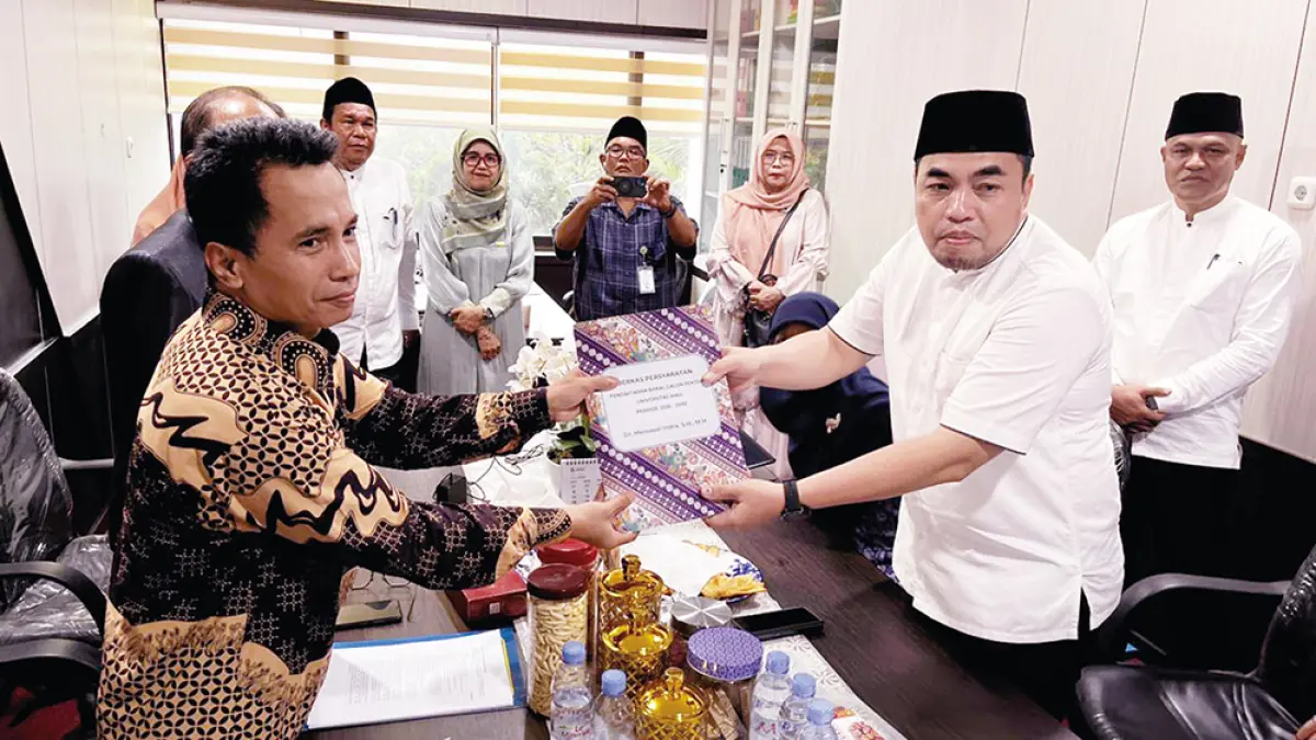 Bakal calon Rektor Unri Dr Mexsasai Indra SH MH (kanan) saat menyerahkan berkas persyaratan pendaftaran bakal calon Rektor Unri kepada Ketua Panitia Pemilihan Rektor Dr HM Rasuli SE MSi Ak Ca ACPA, di Rektorat Unri Lantai 2, Jumat (8/5/2026). (UNRI)

