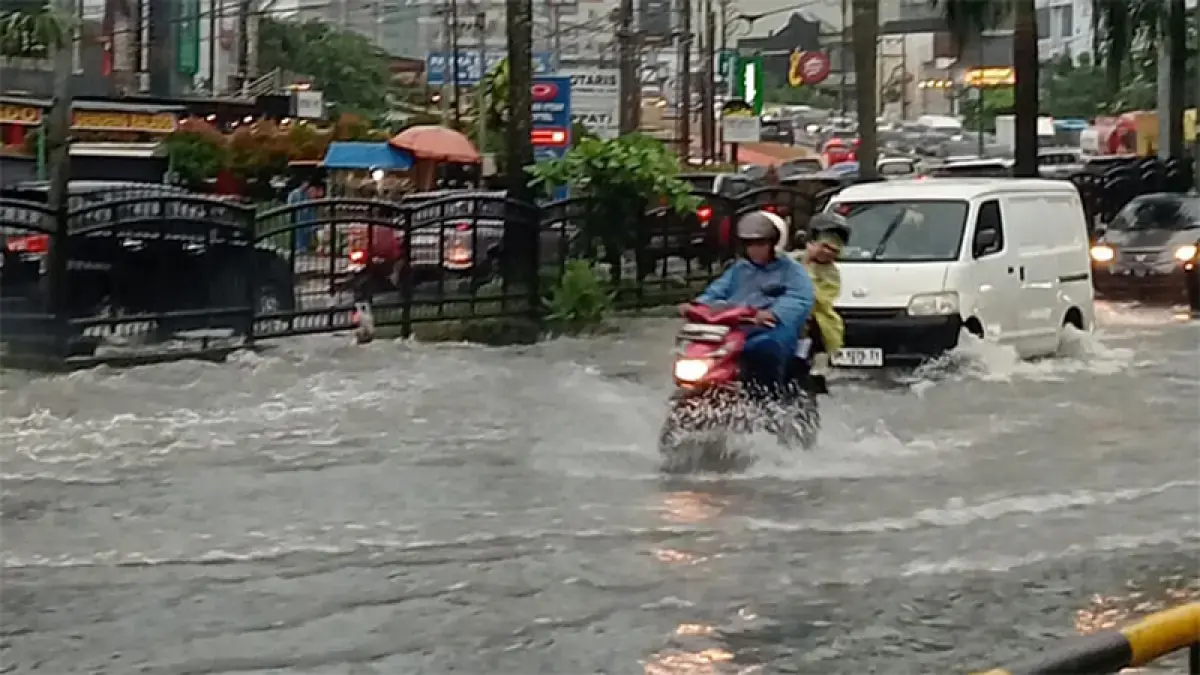 Pengendara motor dan mobil terlihat menerobos genangan air banjir di Jalan Jenderal Sudirman Pekanbaru, Jumat (8/5/2026) lalu. (Dok Riaupos.co)
