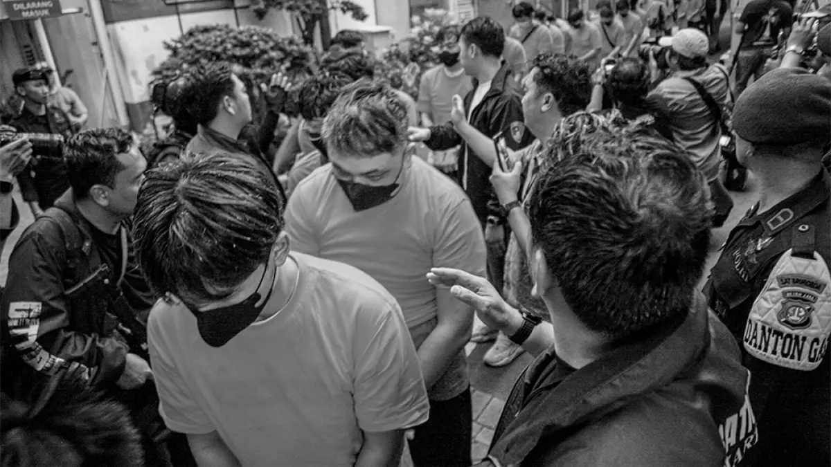 Sejumlah tersangka judi online dikawal ketat oleh aparat kepolisian keluar dari Hayam Wuruk Tower, Jakarta, Ahad (10/5/2026). (HANUNG HAMBARA/JPG)
