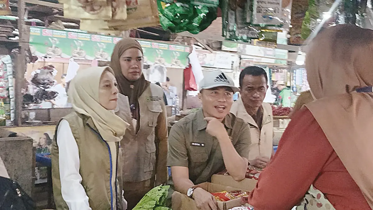 Direktur Ketersediaan Pangan Ba­dan Pangan Nasional (Bapanas) Indra Wijayanto (pakai topi) menanyakan harga jual dan stok Minyakita kepada pedagang di Pasar Dupa Kencana, Senin (11/5/2026). (Prapti Dwi Lestari)