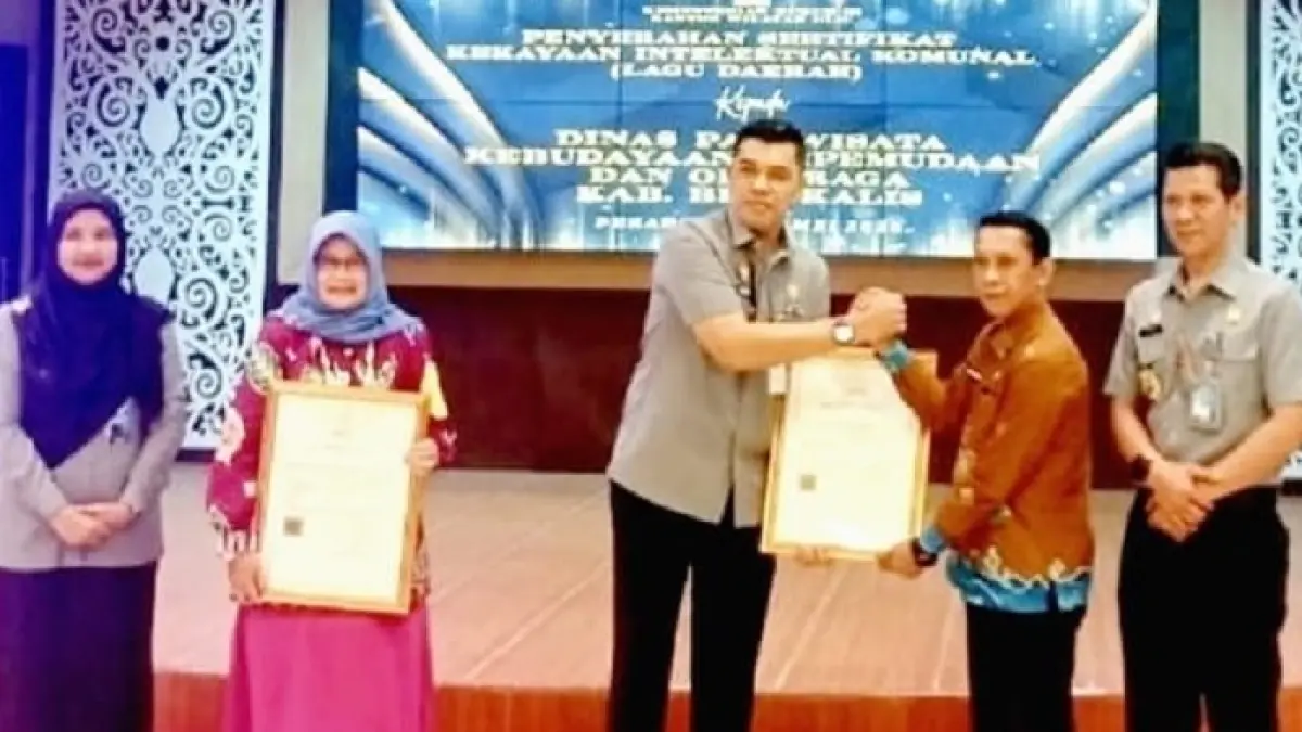 Kakanwil Kemenhum Riau Rudy Hendra Pakpahan serahkan 4 Sertifikat KIK kepada Kadisparbud Rohul H Helfiskar SH MH di Aula Ismail Saleh Kanwil Kemenhum RI Pekanbaru, Selasa (12/5/2026). (Disparbud Rohul untuk Riaupos.co)