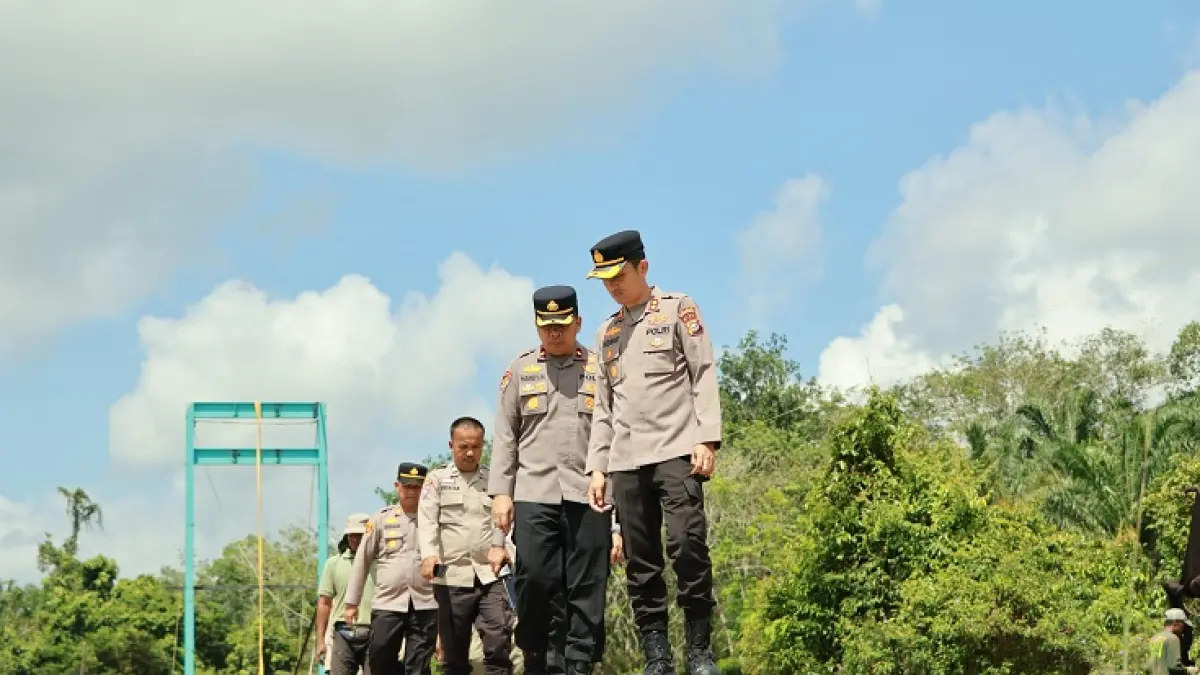 Kapolres Kuansing AKBP Hidayat Perdana SH SIK MH bersama Waka Polres Kompol Nardy Masry SH meninjau jembatan Merah Putih penghubung Desa Jaya-Munsalo Kopah Kecamatan Kuantan Tengah, Selasa (12/5/2026). (Desriandi Candra/Riaupos.co)