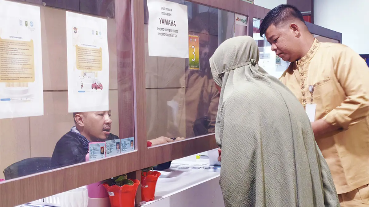Petugas melayani masyarakat yang membayar pajak kendaraan bermotor di Samsat Pekanbaru, baru-baru ini. (MHD AKHWAN/RIAUPOS)