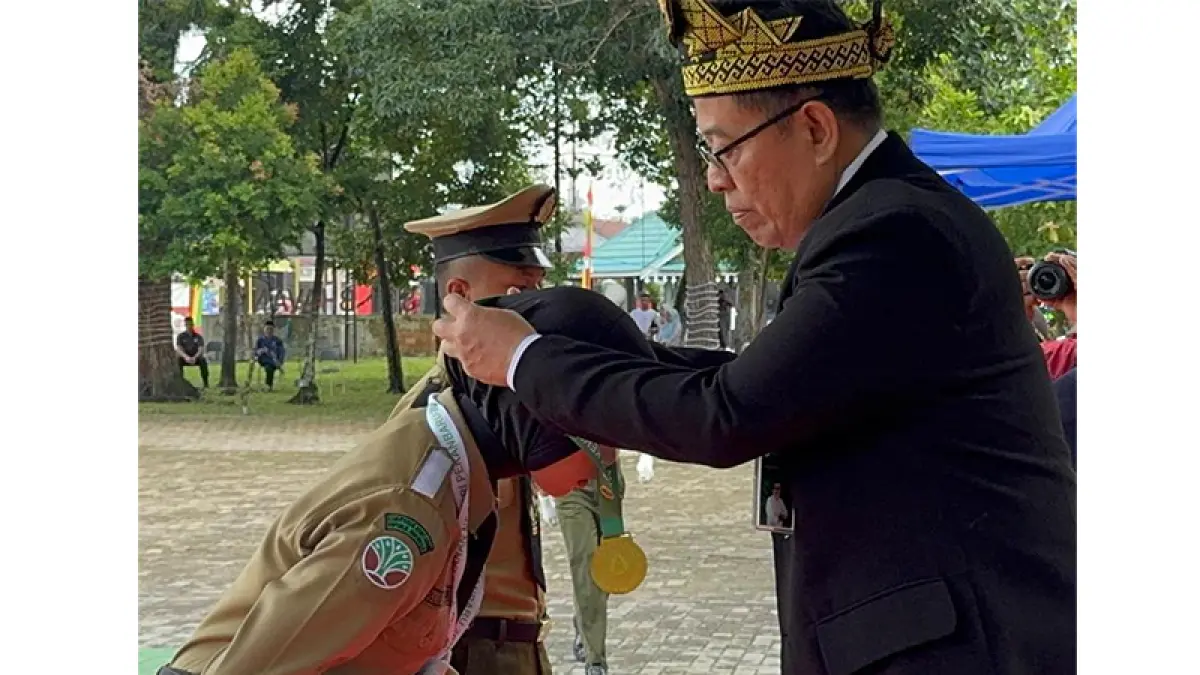 Kepala Pusat Perencanaan Pengembangan SDM Kementerian Kehutanan Dr U Mamat Rahmat SHut MP menyematkan mendali kepada lulusan SMK Kehutanan Pekanbaru, Rabu (13/5/2026). Foto Prapti Dwi Lestari