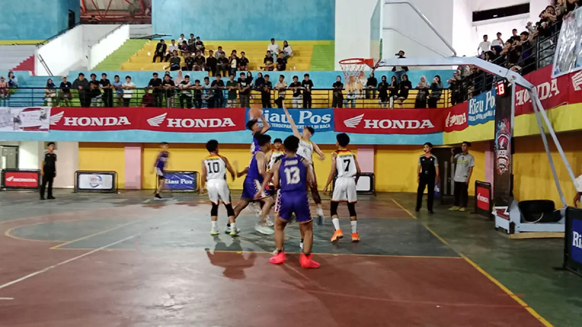 Pebasket MAN 1 Telukkuantan (putih) berusaha mengadang lemparan bola yang dilakukan pebasket SMAN 1 Telukkuantan (ungu) pada pertandingan Riau Pos-HSBL Telukkuantan Series  2026 di GOR A Sport Center Kuansing, Kamis (14/5/2026).  (desriandi candra/riau pos)