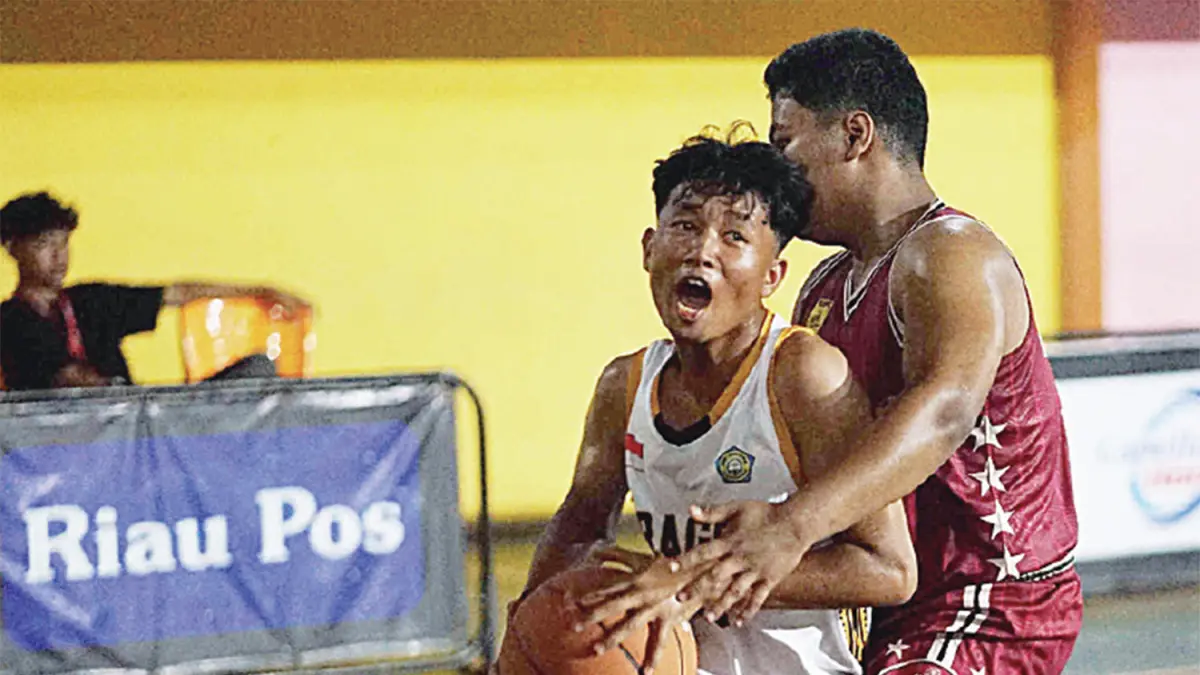 Pemain putra Mudik (merah) mengadang pemain putra SMAN 1 Kuantan Hilir (putih) pada Riau Pos HSBL 2026 Telukkuantan Series di Lapangan Hall A Sport Center Kuansing, Rabu (13/5/2026).