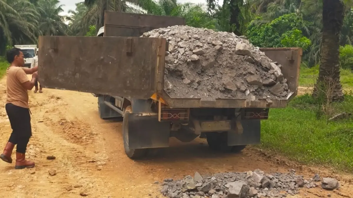 Material batu base untuk perbaikan jalan elak menghubungkan Desa Petalogan dengan Kelurahan Sekar Mawar Kecamatan Pasir Penyu mulai didatangkan, Senin (18/5/2026). (Pemdes Petalogan)