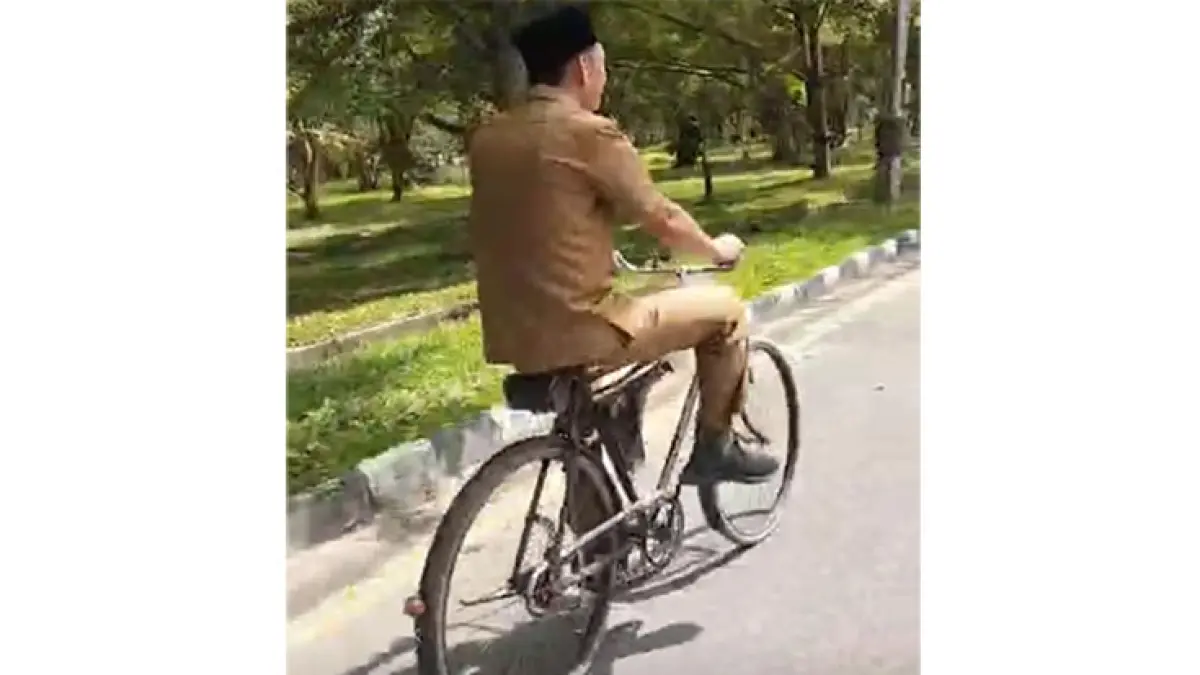 Kadisdukcapil Indra Maryanto sedang mengayuh sepedanya menuju kantornya di Komplek Perkantoran Sungai Betung Siak, Selasa (19/5/2026). (Istimewa)