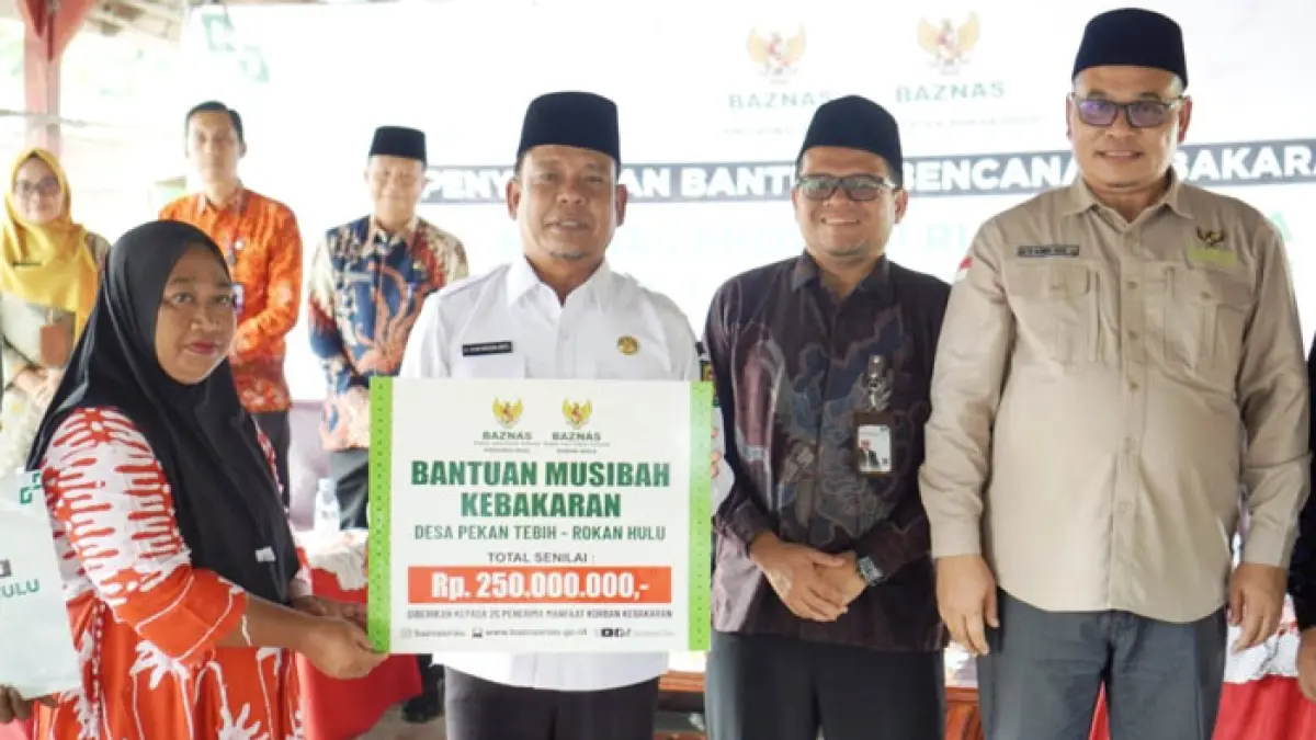 Wabup Rohul H Syafaruddin Poti serahkan bantuan Baznas Riau dan Baznas Rohul senilai Rp 437,5 juta kepada perwakilan warga yang rumahnya terdampak kebakaran di Pasar Pekan Tebih, Kecamatan Kepenuhan Hulu, Kamis (21/5/2026). (Dinas Kominfo Rohul untuk Riaupos.co)