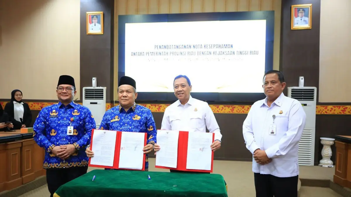 Plt Gubri SF Hariyanto bersama Kajati Riau I Dewa Gede Wirajana memperlihatkan hasil penandatanganan MoU, Rabu (20/5/2026). (Diskominfo Riau untuk Riau Pos)