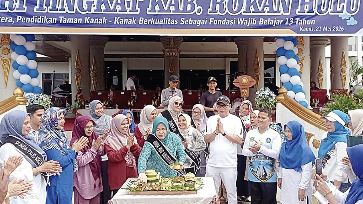 Bunda PAUD Rohul dr Yeni Dwi Putri didampingi Plt Kadisdikpora Rohul Alreza Ahyu memotong nasi tumpeng dalam acara peringatan HUT ke-76 IGTKI-PGRI tingkat kabupaten di halaman Kantor Bupati Rohul, Kamis (21/5/2026). (DINAS KOMINFO ROHUL UNTUK RIAU POS)