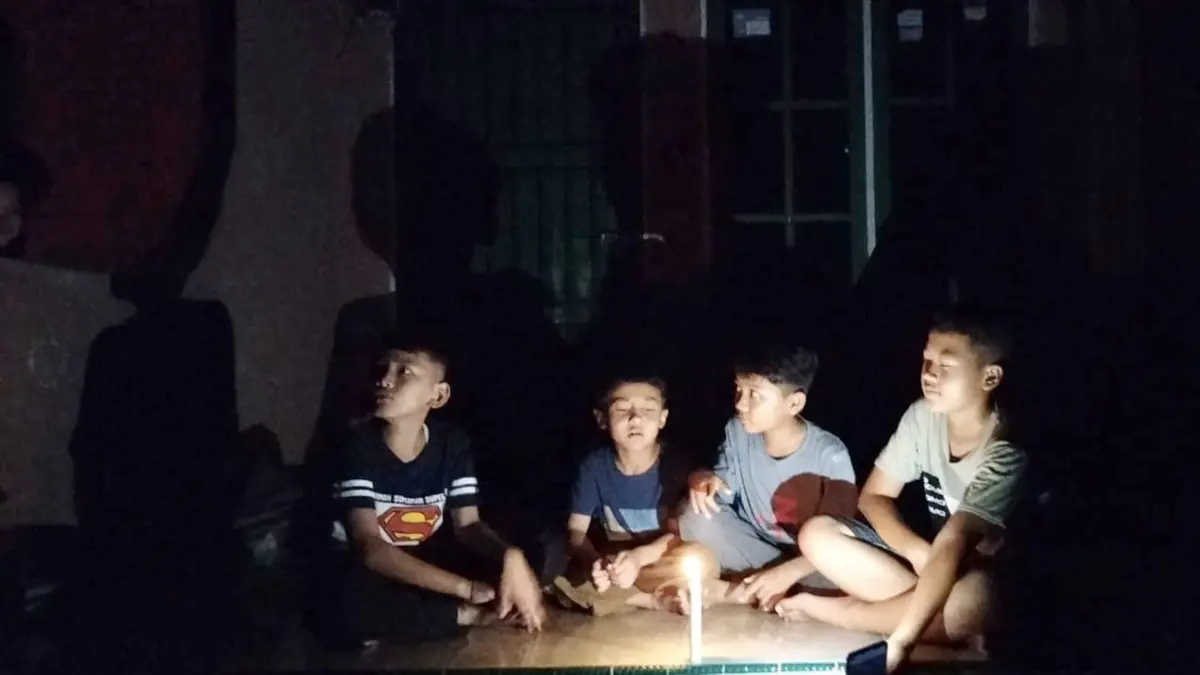 TEKS FOTO: Sejumlah anak-anak sedang bermain lilin di depan teras rumah saat listrik padam di Desa Koto Tinggi, Kecamatan Rambah, Rohul.Jumat (22/5/2026) malam.(ENGKI PRIMA PUTRA/RIAUPOS.CO)
