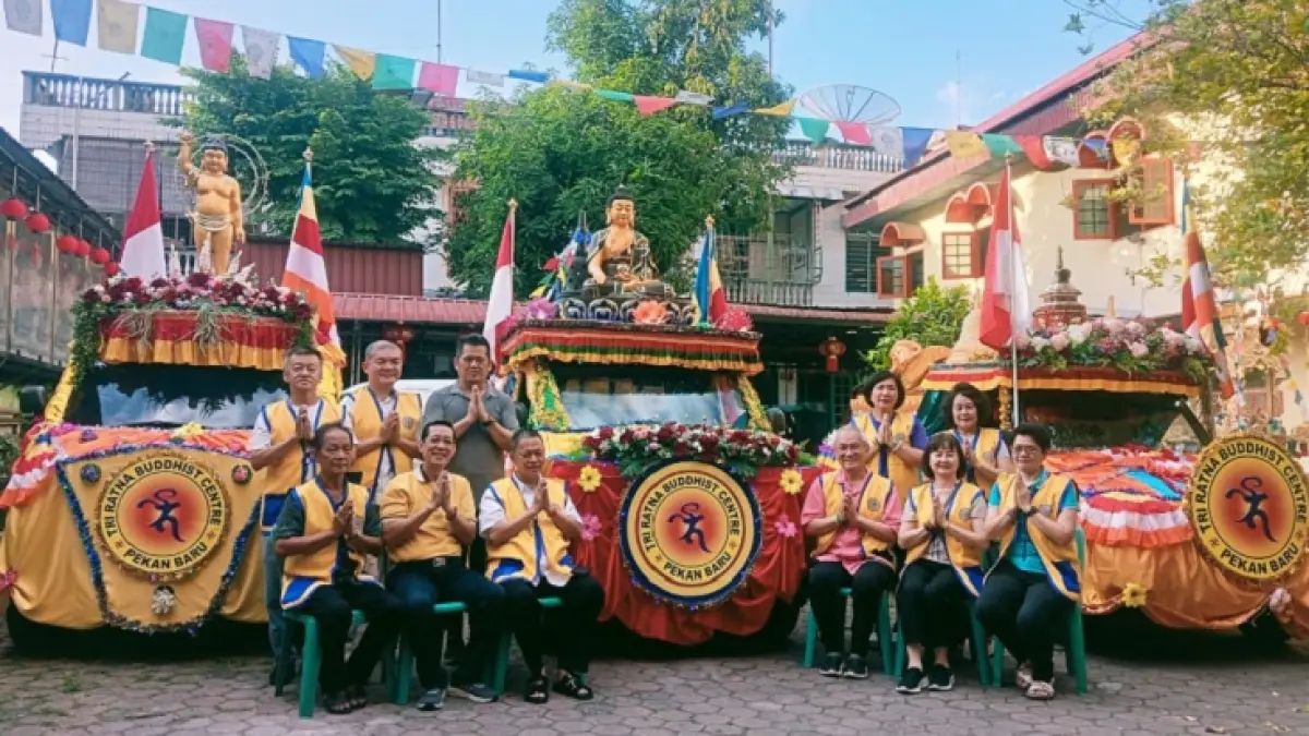 Ketua Panitia Waisak Bersama, Aniruddha Tan didampingi Sekretaris Panitia Vina Anggreni dan jajaran panitia Waisak Bersama 2570 BE foto bersama didepan mobil hias yang akan ditampilkan dalam pawai Waisak sore ini, Sabtu (23/5/2026). (Prapti Dwi Lestari/Riaupos.co)
