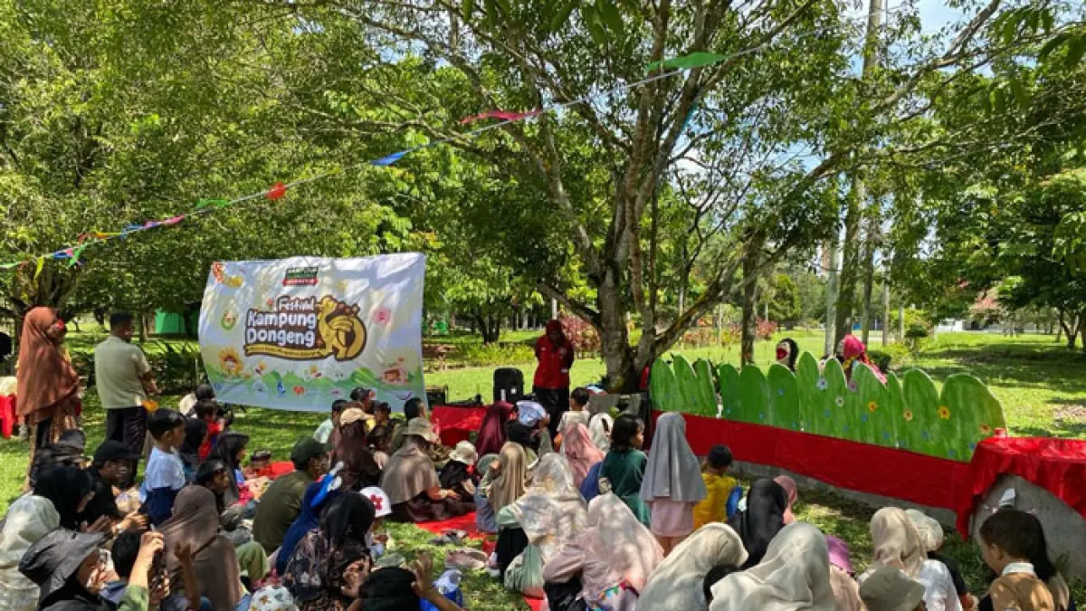 Anak-anak mendengarkan dongeng boneka pada kegiatan festival kampung dongeng 2026 di Lapangan Universitas Riau, Ahad (24/5/2026). (Soleh Saputra/Riaupos.co)