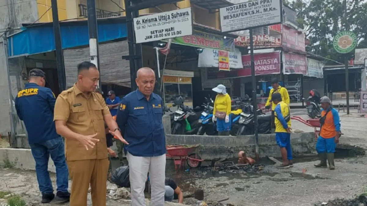 Lurah Maharatu Joko Arif Santoso berbincang dengan salah satu pejabat Dinas PU Pekanbaru saat pembersihan drainase yang tersumbat. (Istimewa)