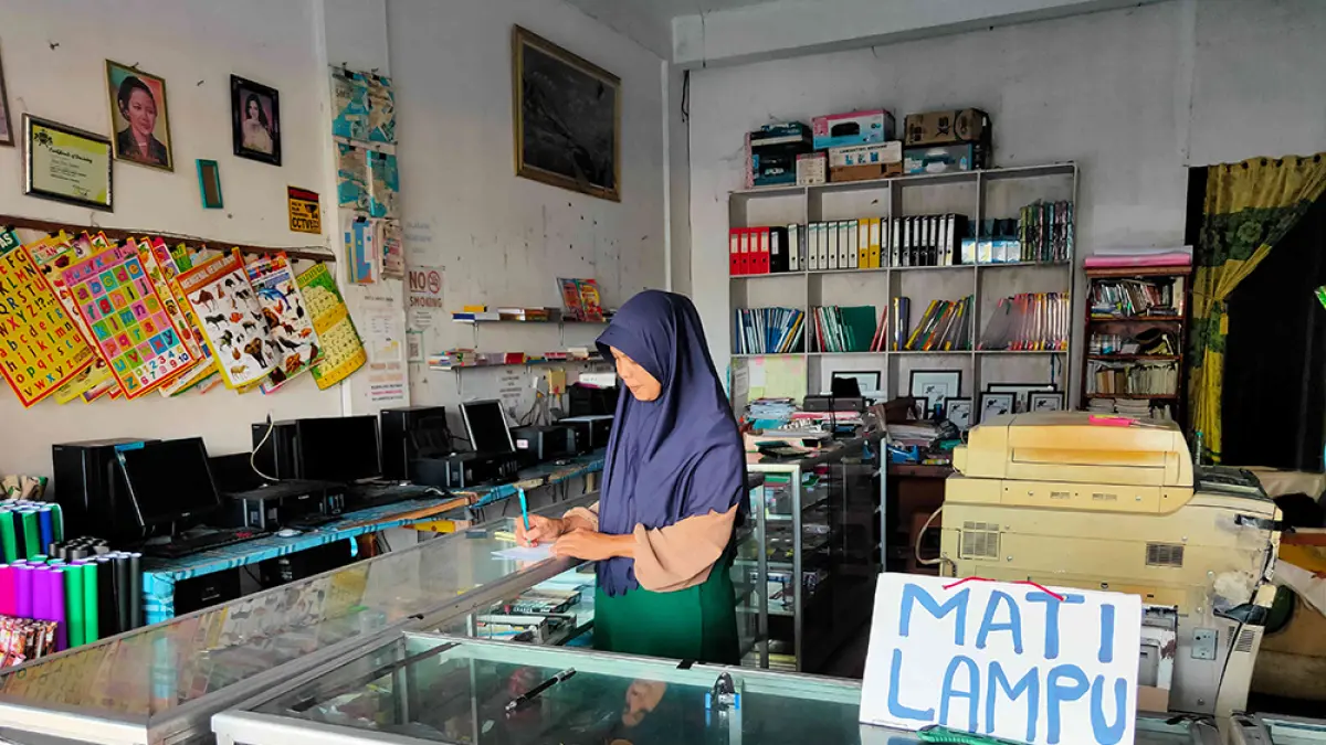 Pemilik usaha ATK memasang pemberitahuan mati lampu di tempat usahanya di Jalan Delima, Kecamatan Binawidya Pekanbaru, Sabtu (23/5/2026).(EVAN GUNANZAR/RIAU POS)