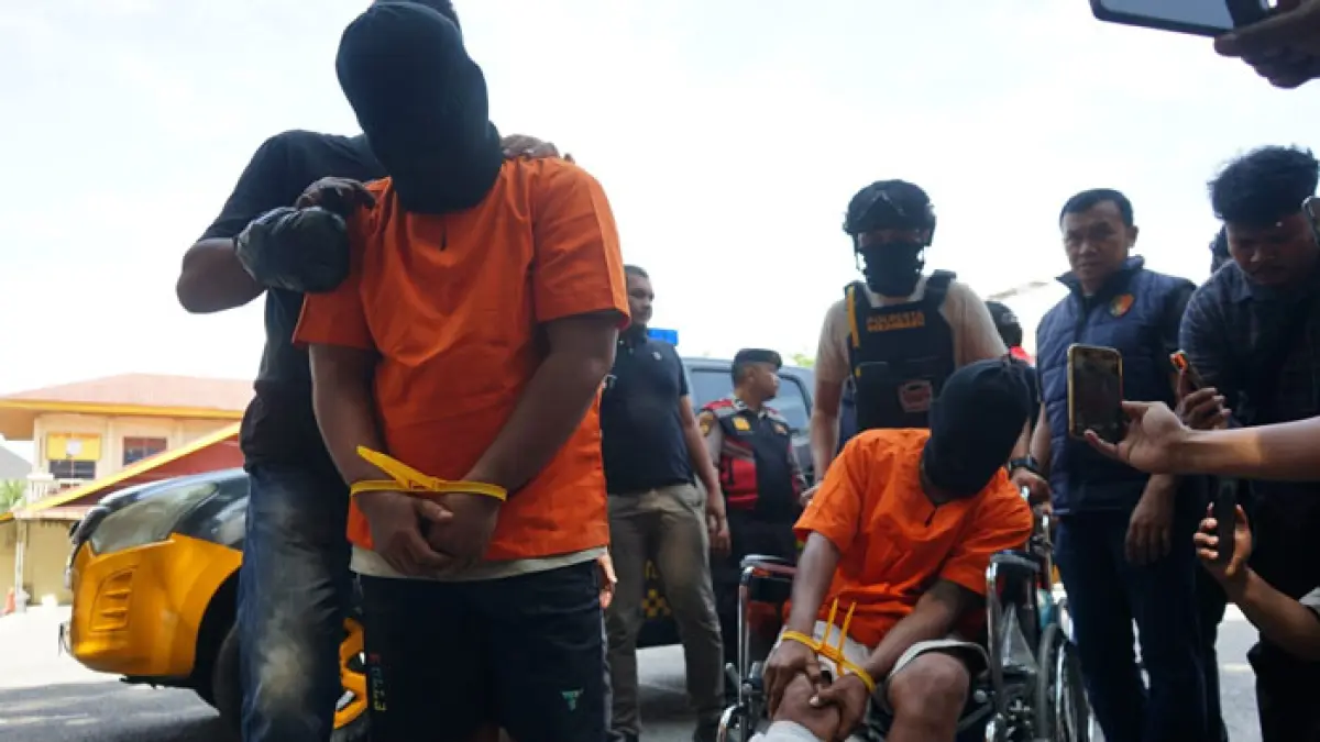 Petugas Kepolisian menggiring tersangka pembunuhan saat ekspos di Mapolresta Pekanbaru, Ahad (24/5/2026). (Evan Gunanzar/Riau Pos)