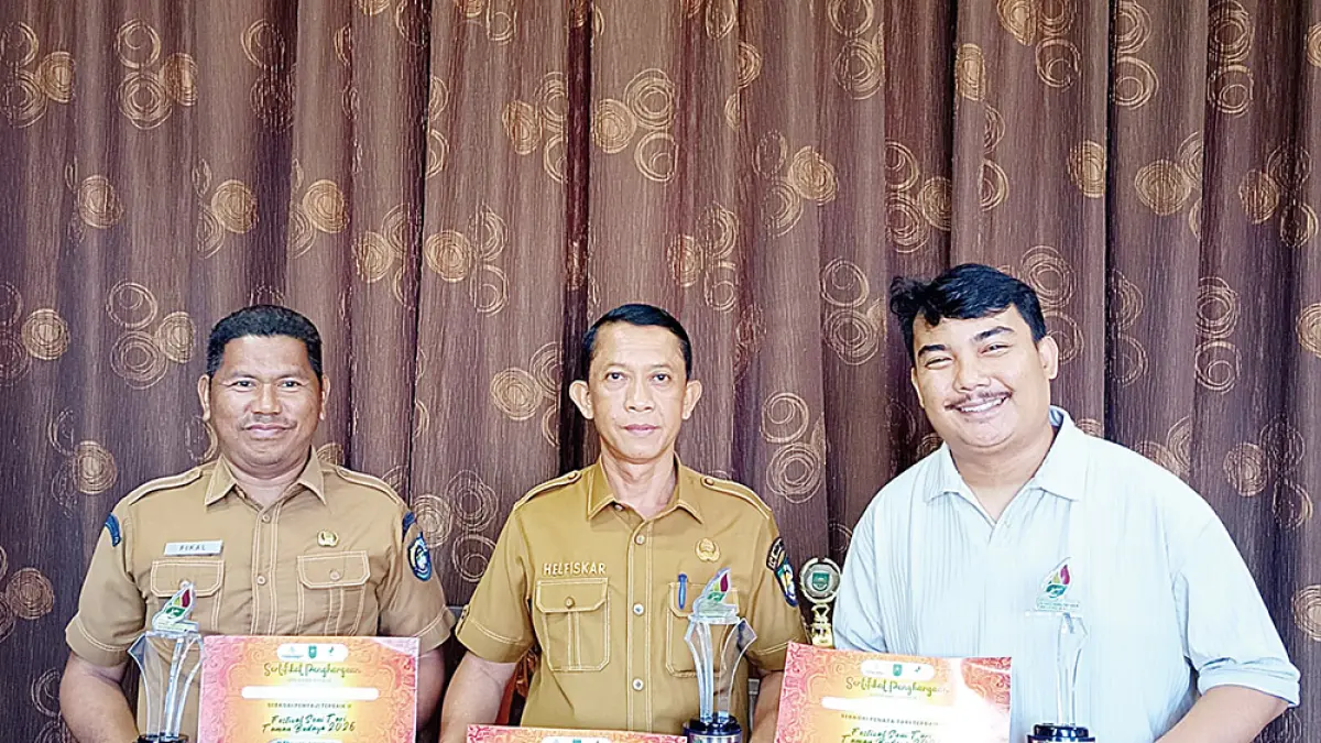 MENUNJUKKAN PRESTASI: Kadisparbud Rohul H Helfiskar (tengah) didampingi Penata Tari dari Rumah Seni Balai Proco Afri Nanda Islami menunjukkan tiga prestasi yang diraih Kabupaten Rohul dalam ajang&nbsp;FSTTB&nbsp;Se-Riau 2026 di ruang kerjanya, Senin (25/5/2026). (DINAS KOMINFO ROHUL UNTUK RIAU POS). 


