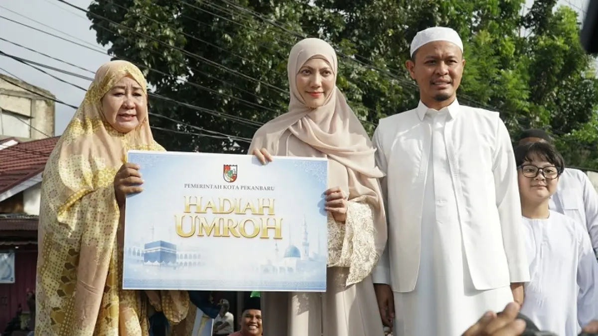 Wali Kota Pekanbaru H Agung Nugroho dan Ibu Sulastri menyerahkan hadiah umrah usai pelaksanaan Salat Id di Perumahan Sidomulyo,Pekanbaru, Rabu (27/5/2026). (MHD AKHWAN/RIAUPOS)