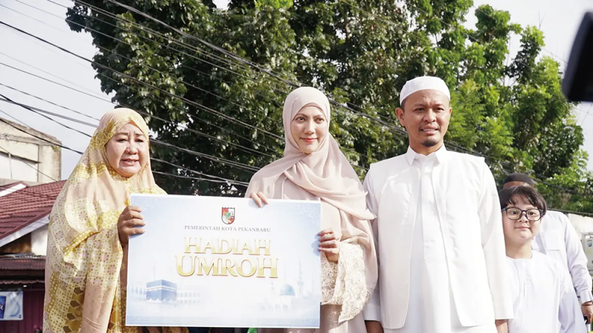 Wali Kota Pekanbaru H Agung Nugroho dan istri Sulastri menyerahkan hadiah umrah kepada warga yang beruntung usai pelaksanaan Salat Iduladha di Perumahan Sidomulyo, Kecamatan Marpoyan Damai, Rabu (27/5/2026). (MHD AKHWAN/RIAU POS )