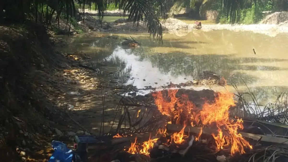 Personel Polres dan Polsek Kuantan Tengah bakar dia rakit PETI jenis Setingkai yang ditemukan di lokasi, Jumat (29/5/2026). (Polsek Kuantan Tengah untuk Riaupos.co)