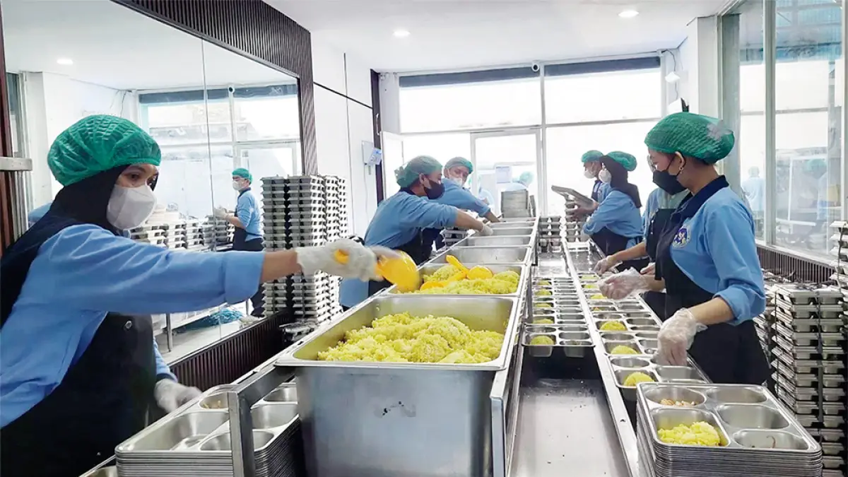Para pekerja sedang melakukan kegiatan pemorsian MBG di sebuah dapur SPPG.(JPG)