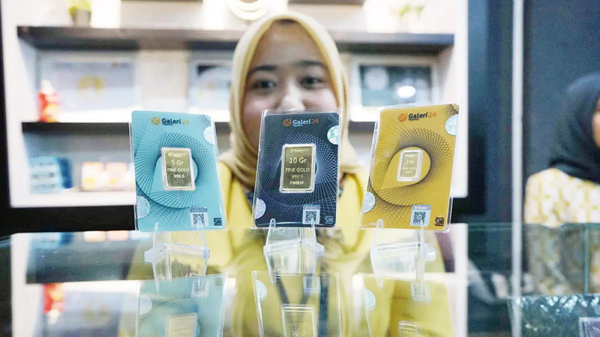 Karyawan memperlihatkan emas batangan yang dijual di salah satu tempat penjualan emas di Jalan Jenderal Sudirman, Pekanbaru, beberapa waktu lalu. (EVAN GUNANZAR/RIAU POS)
