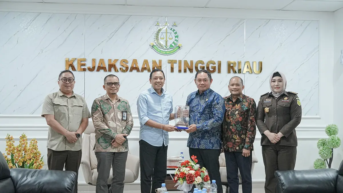 General Manager PLN UIP Sumbagteng Achmadi Abbas (tiga kanan) menyerahkan cendera mata kepada Kajati Riau I Dewa Gede Wirajana saat audiensi, Selasa (2/6/2026). (pt pln (persero) untuk riau pos)
